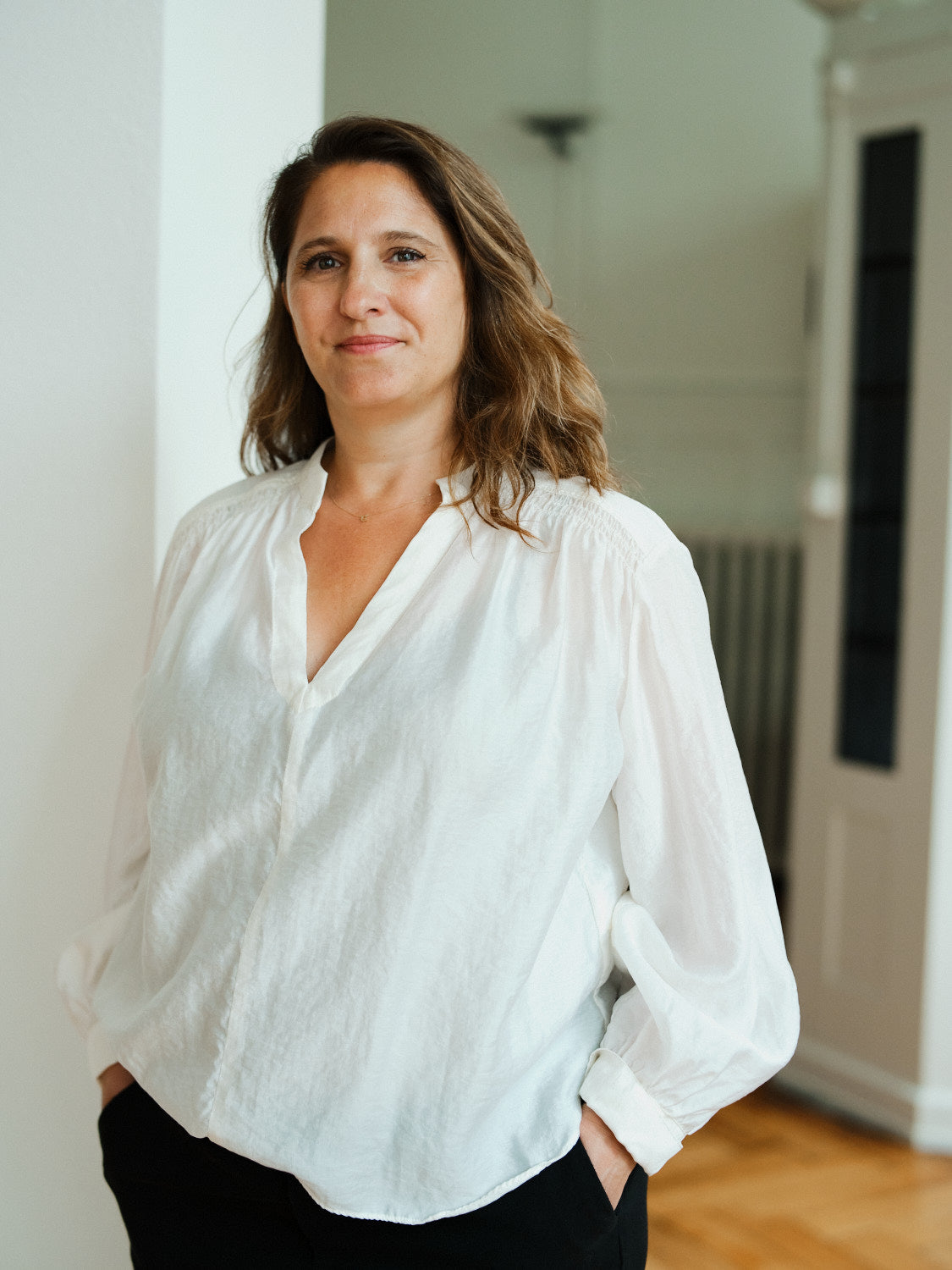 Elegant white linen blouse with relaxed fit, long sleeves, and a button-up front, perfect for casual or professional wear.